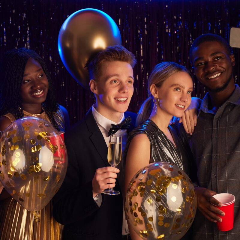 Elegant school formal venue with a beautifully decorated ballroom, vibrant lighting, and a dance floor filled with students celebrating.